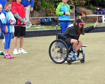 Girl sitting in a wheelchair playing bowls